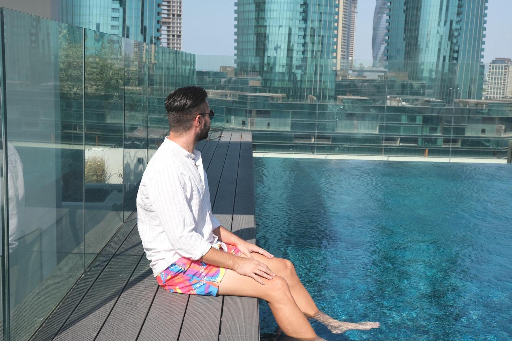 Charthouse Bahrain Hotel Manáma Kültér fotó A man sitting on the edge of a pool